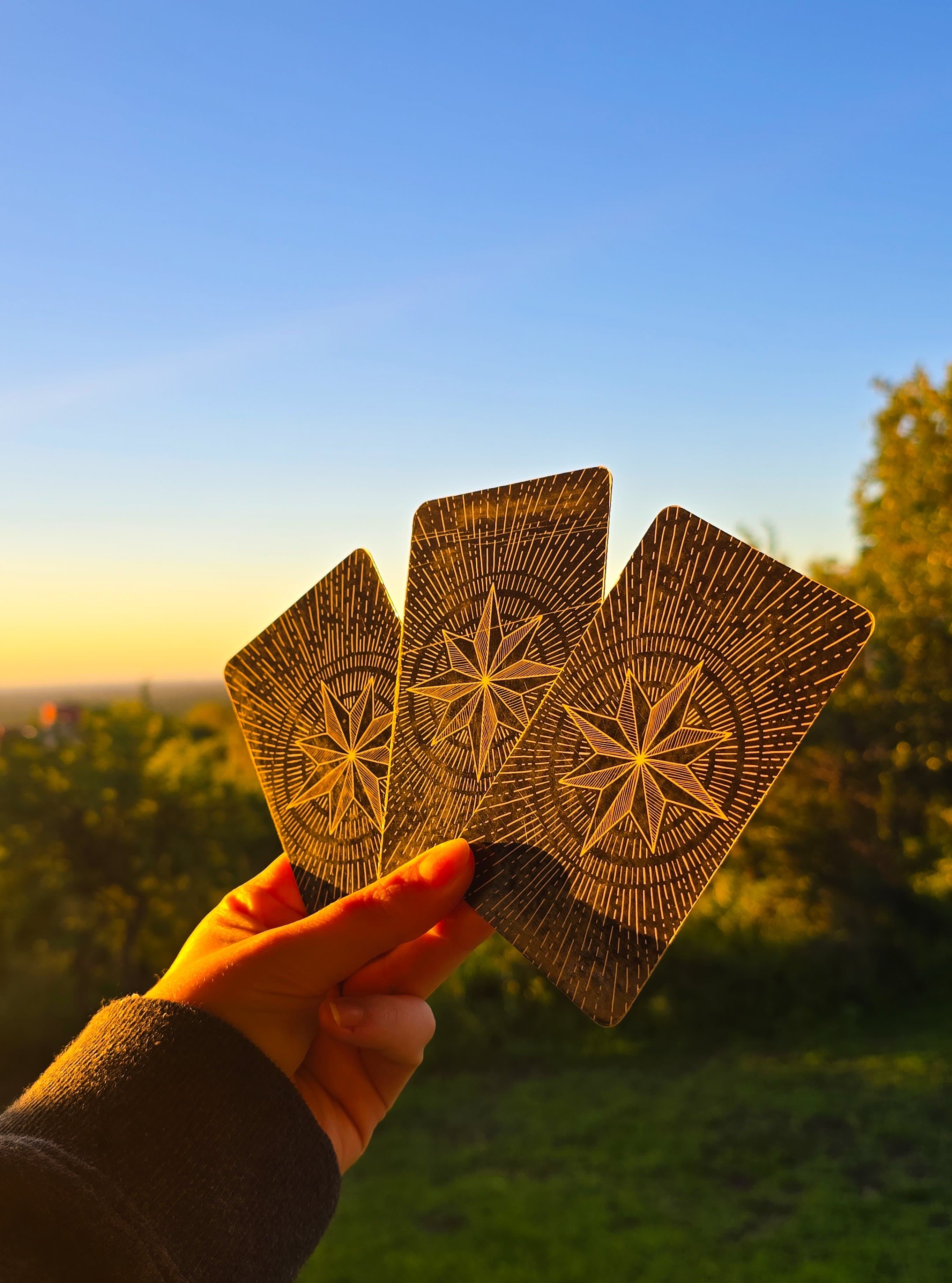 Tres cartas doradas con brújulas a contraluz dorada
